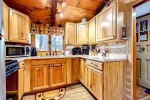a kitchen with wooden cabinets and a stove at White Mountain Grove in Conway