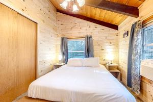 um quarto com uma cama num chalé de madeira em White Mountain Grove em Conway