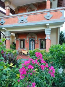 a house with pink flowers in the garden at Hotel Grand Kumala Bali in Legian