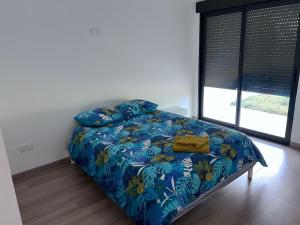 uma cama com um edredão azul e almofadas num quarto em VILLA LENA em Sainte-Geneviève-des-Bois