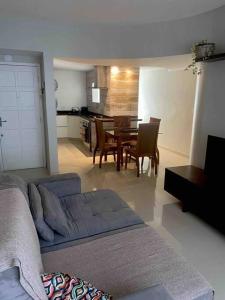 Una sala de estar con un sofá y una mesa con sillas. en Confortável Apartamento em Angra dos Reis, en Angra dos Reis