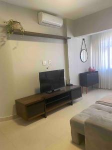 Una sala de estar con un televisor de pantalla plana sobre una mesa. en Confortável Apartamento em Angra dos Reis, en Angra dos Reis