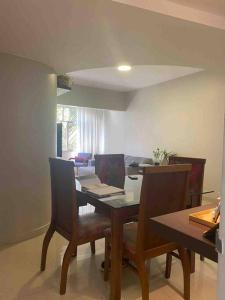Un comedor con una mesa y sillas con una computadora portátil. en Confortável Apartamento em Angra dos Reis, en Angra dos Reis 7 fotos más