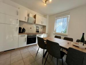 a kitchen with a table and chairs and a refrigerator at Ferienhaus Brockenpfad in Schierke