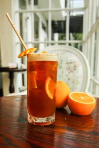 a drink on a wooden table with an orange slice at Kaffberry Cafe & Homestays in Kūd