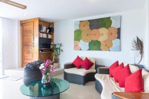 una sala de estar con 2 sofás y una mesa con almohadas rojas. en Villa Stella 16 Santi Thani Maenam, en Nathon Bay