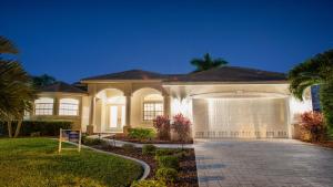 a large white house with a garage at Boaters Dream S. Terr Pool Yacht Club Boating in Cape Coral
