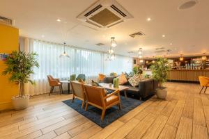 a hotel lobby with a table and chairs at Holiday Inn Cardiff City, an IHG Hotel in Cardiff