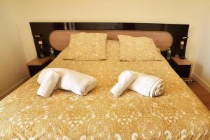 a bed with two white towels on top of it at La Villa d’Emma in Mougins