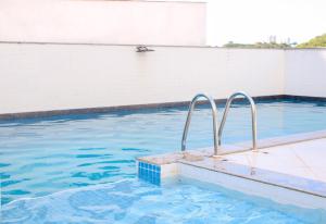 - une piscine avec des rails bleus et métalliques dans l'établissement Axé home - Apartamento conceito em Salvador, à Salvador