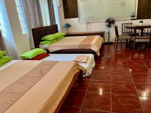 een kamer met drie bedden en een tafel met een projector bij MARIKINA 32 sqm Studio for Transients w WiFi 40 inch TV Parking in Manilla