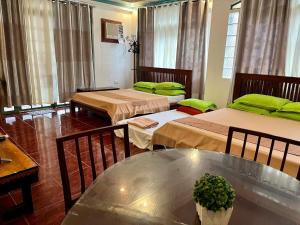 a room with three beds and a glass table at MARIKINA 32 sqm Studio for Transients w WiFi 40 inch TV Parking in Manila