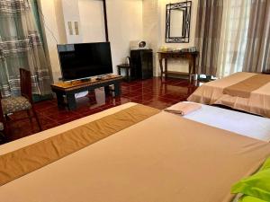 Habitación de hotel con 2 camas y TV de pantalla plana. en MARIKINA 32 sqm Studio for Transients w WiFi 40 inch TV Parking en Manila