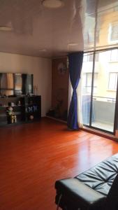 sala de estar con suelo de madera y cortina azul en Apartamento Conjunto Residencial Yerbabuena, en Soacha