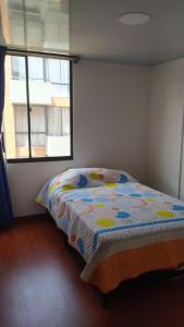 een slaapkamer met een bed in een kamer met een raam bij Apartamento Conjunto Residencial Yerbabuena in Soacha