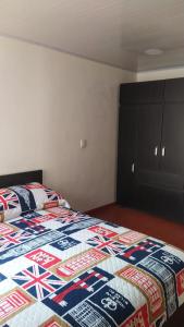 a bedroom with a bed with a quilt on it at Apartamento Conjunto Residencial Yerbabuena in Soacha