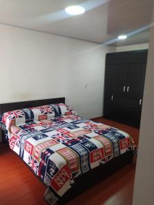 a bedroom with a bed with a quilt on it at Apartamento Conjunto Residencial Yerbabuena in Soacha