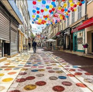 una calle de la ciudad con globos y una acera con una persona caminando en Au p'tit Lagny - rue piétonne, en Lagny