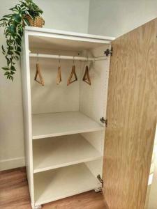 un armario blanco con perchas y una maceta en Au p'tit Lagny - rue piétonne, en Lagny