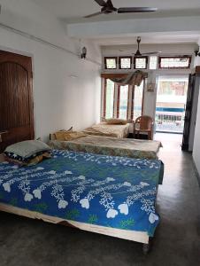 a bedroom with two beds in a room with windows at Ajanta Lodge in Guwahati