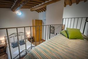 Un dormitorio con una cama con una almohada verde. en Podere Fossaccio Casa Pino, en Asciano