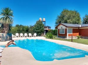 a man is swimming in a swimming pool at Cabañas Matices del Lago in Villa Ciudad Parque