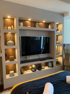 a living room with a flat screen tv on a wall at NatySweethome in Magny-le-Hongre