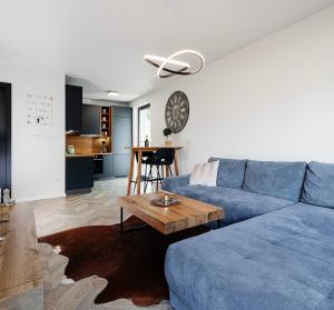 a living room with a blue couch and a table at Garden Apartment in Banská Bystrica