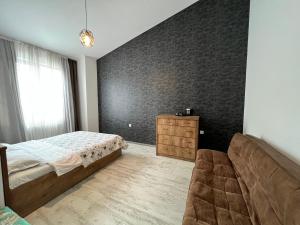 兹内特耶Guest House PIROSMANI的一间卧室配有一张床、一张沙发和一面墙