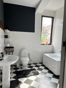 a bathroom with a tub and a toilet and a sink at Guest House PIROSMANI in Tsqnetʼi