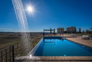una fuente de agua frente a una piscina en Podere Fossaccio Casa Pino, en Asciano