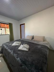a bedroom with a bed with two pairs of shoes on it at Chalé encontro dos rios in Nova Friburgo