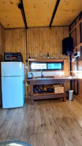 een keuken met een witte koelkast en een houten vloer bij Aerohouse in Posadas