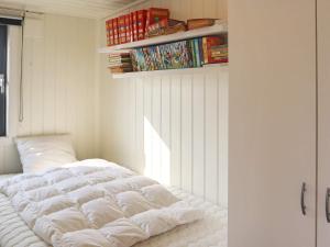 uma cama branca num quarto com uma janela em Holiday home Søndeled em Søndeled