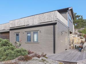 une petite maison avec un garage en bois dans l'établissement Holiday home Søndeled, à Søndeled