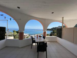 einen Balkon mit einem Tisch und Meerblick in der Unterkunft Harbour View - Oceanis Apartments in Póros