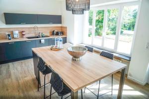 eine Küche mit einem Holztisch und einigen Stühlen in der Unterkunft Le Domaine du Pavillon • L'idyllique en Brenne in Nuret-le-Ferron