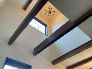 a ceiling with wooden beams and a chandelier at レンタルヴィラ岐阜各務原-8名宿泊可-ペット可 in Kakamigahara