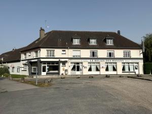 un grand bâtiment blanc avec un toit noir dans l'établissement LE RELAIS DES HAYONS, 