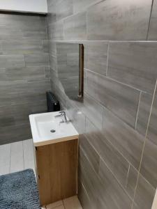 a bathroom with a white sink and a wall at Droitwich Spa centre apartment in Droitwich