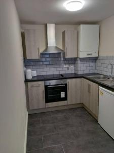 a kitchen with white cabinets and a stove top oven at Droitwich Spa centre apartment in Droitwich +21 photos