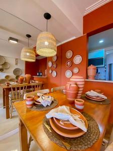 uma sala de jantar com uma mesa com pratos e tigelas em Axé home - Apartamento conceito em Salvador em Salvador