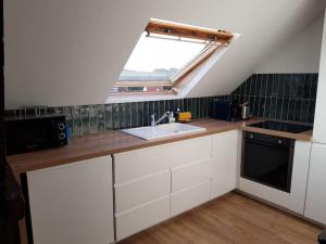 a kitchen with a sink and a skylight at Au gré du vent in Wimereux