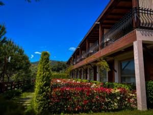 a building with a garden of flowers next to it at Assos Longevity Hotel in Sokakagzi