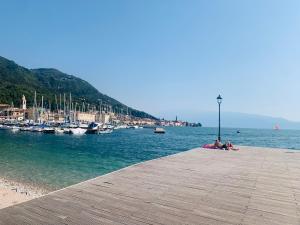a group of people sitting on a dock near the water at LaMonica.House in Salò +5 photos