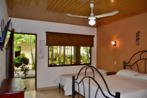 a bedroom with a bed and a large window at Hotel D'Lucia - Quebrada Ganado, Jaco, Costa Rica in Puntarenas
