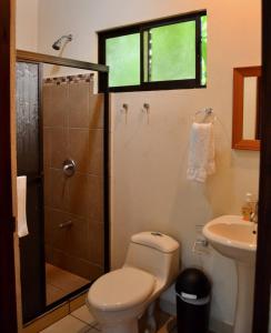 a bathroom with a toilet and a shower and a sink at Hotel D'Lucia - Quebrada Ganado, Jaco, Costa Rica in Puntarenas