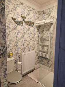 a bathroom with a toilet and a wall at Isla Rose Cottage in Blairgowrie