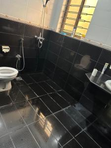 a black tiled bathroom with a toilet and a shower at Bahria Town - 10 Marla 2 Bed rooms Portion for families only in Lahore