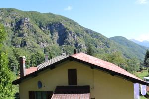 a small house with a mountain in the background at Appartamento Nando in Pian di Novello